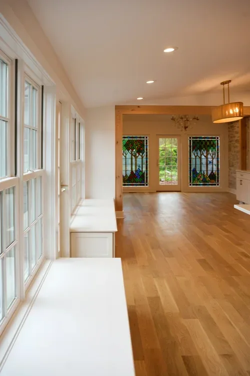 Bright sunroom with hardwood floors, vaulted ceiling, recessed lights, and stained glass windows