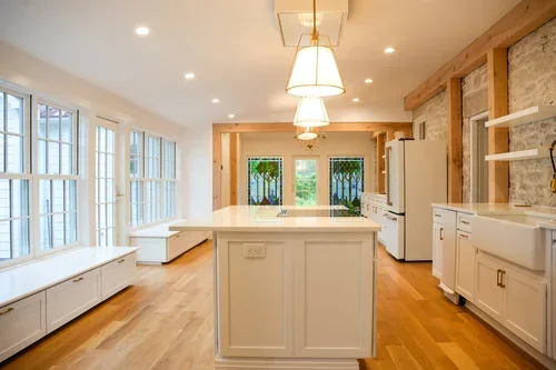 Modern kitchen with white island, hardwood floors, and recessed ceiling lights