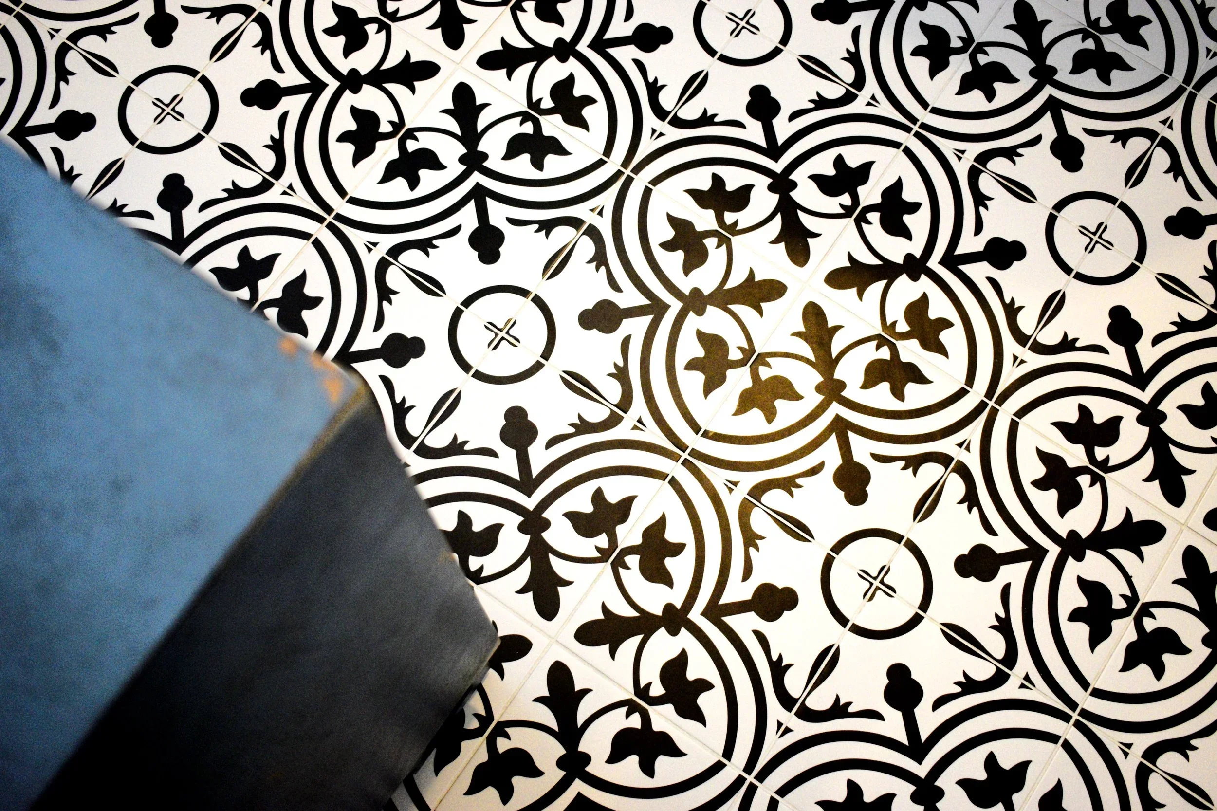 Black and white decorative floor tiles with geometric and floral patterns installed professionally